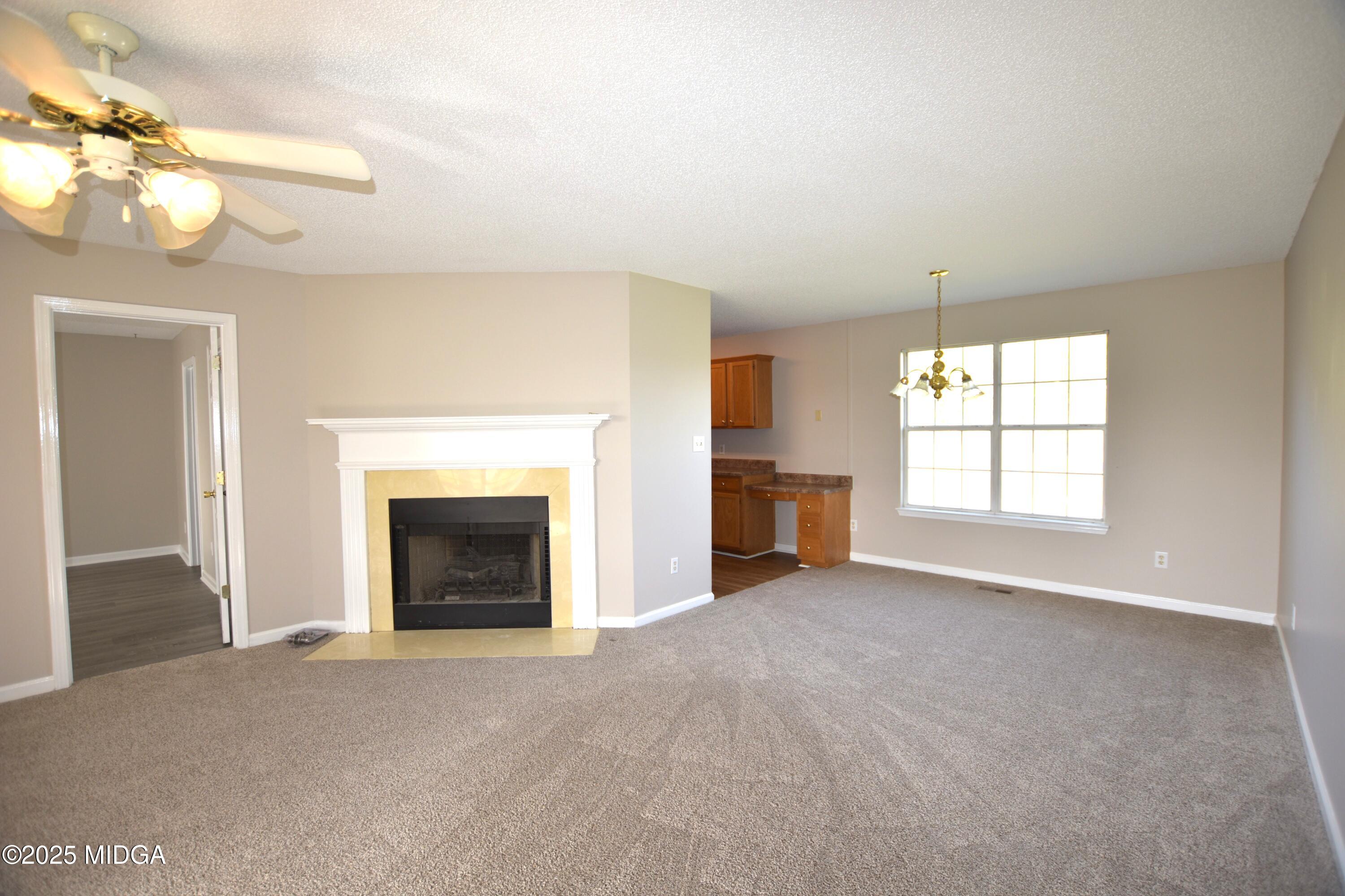 6550 Skipper Road Macon, GA 31216 - Photo 19 of 35 wooden floor fireplace and windows in an empty room