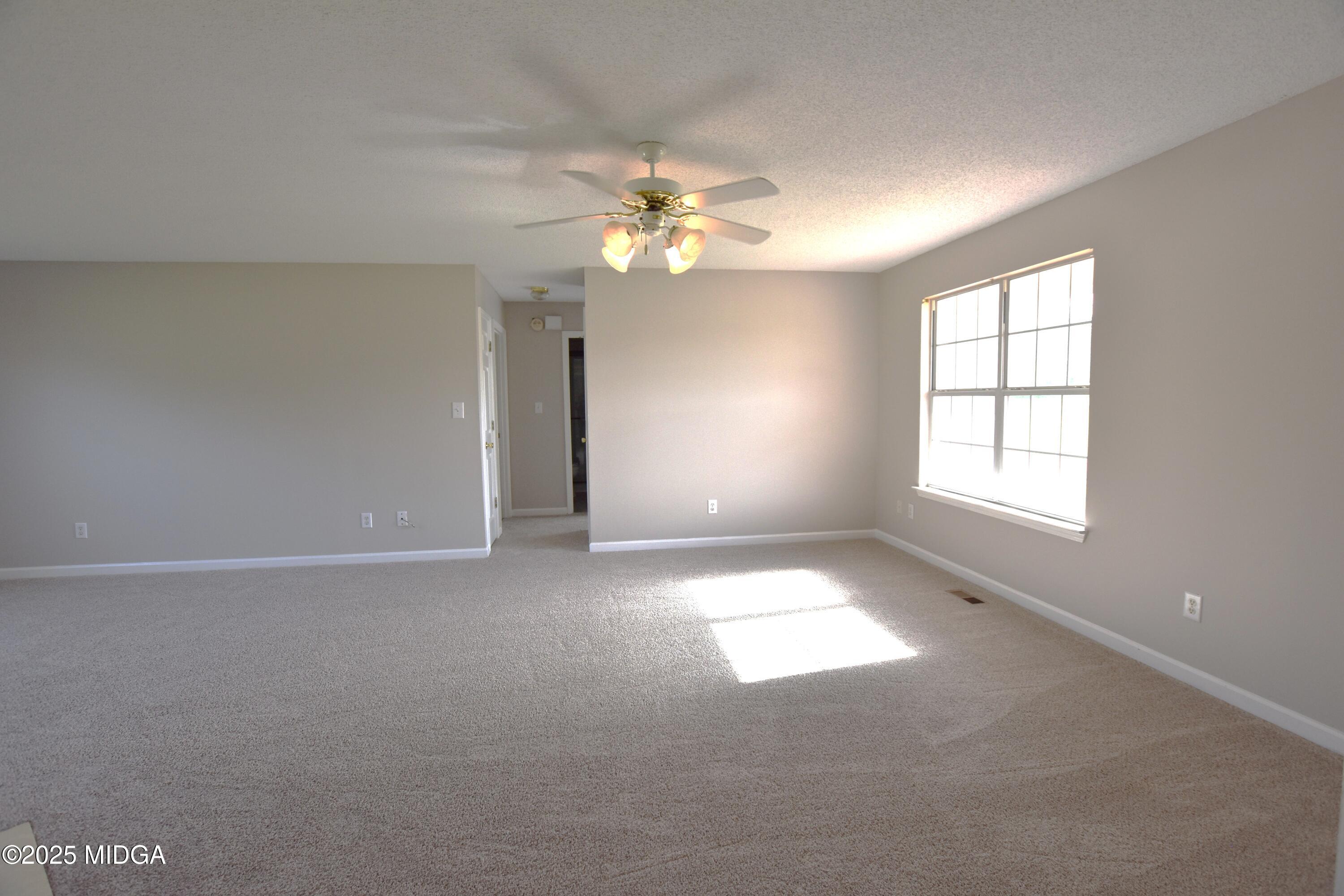 6550 Skipper Road Macon, GA 31216 - Photo 21 of 35 an empty room with windows and fan