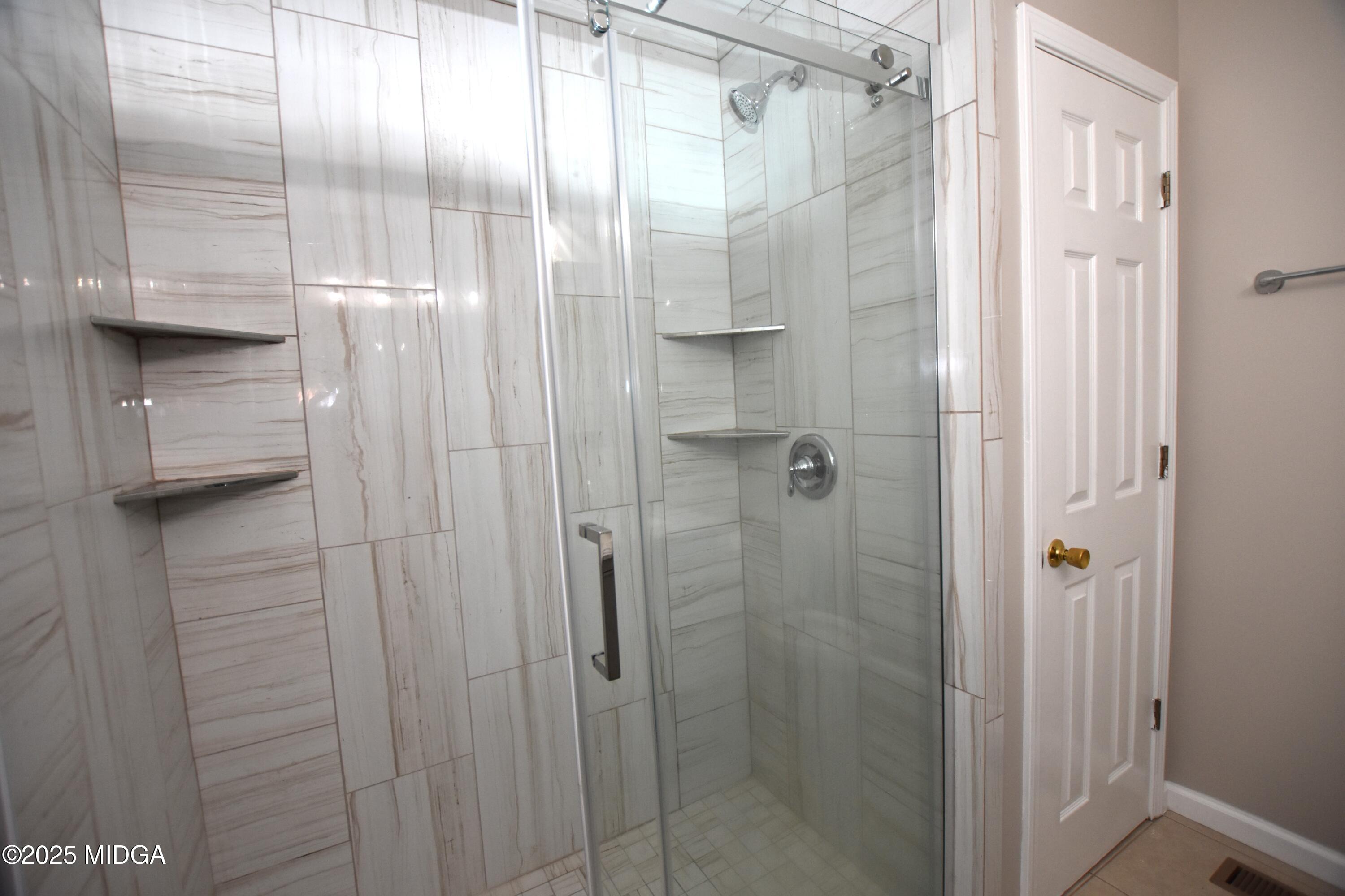 6550 Skipper Road Macon, GA 31216 - Photo 23 of 35 a bathroom with a glass shower door