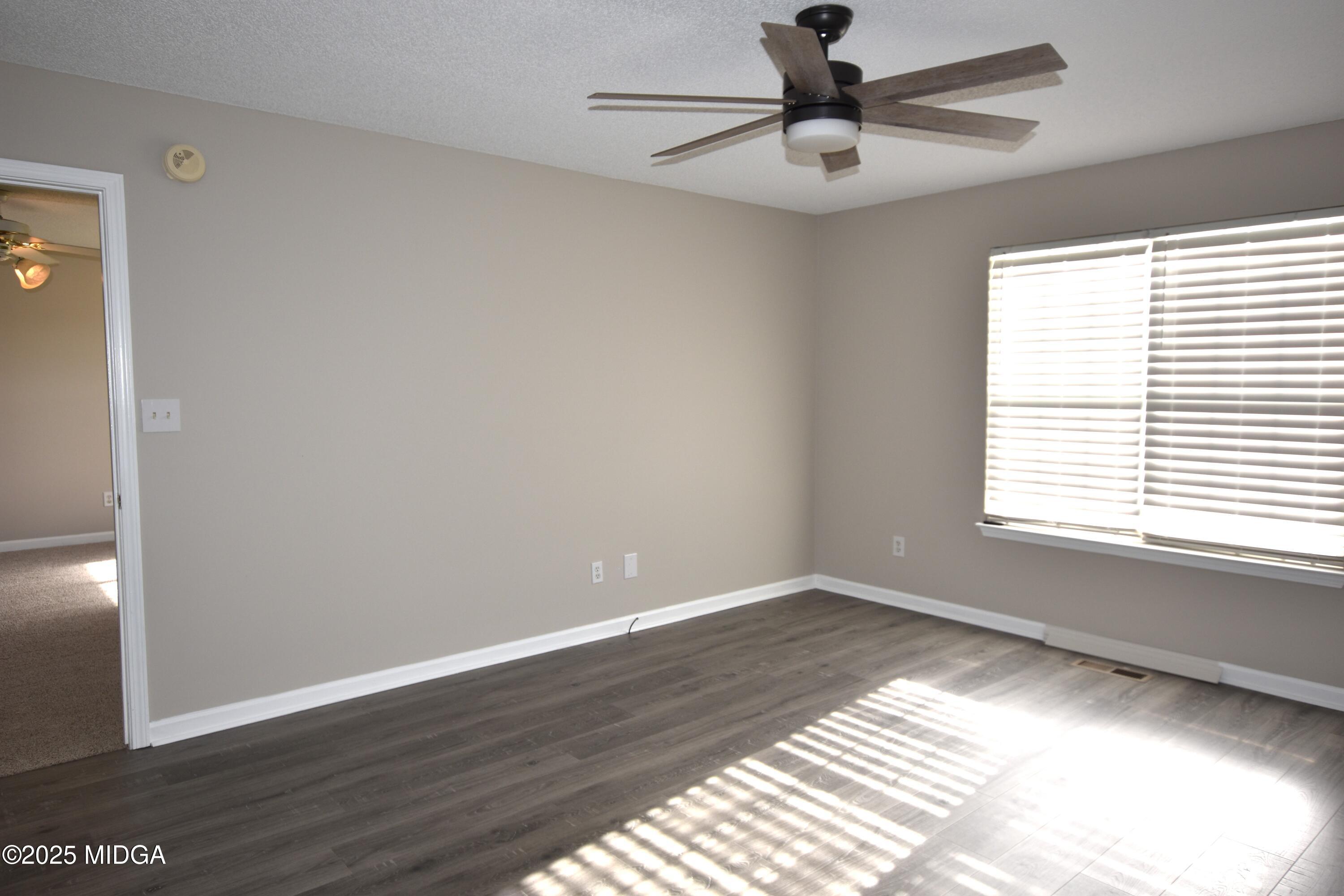 6550 Skipper Road Macon, GA 31216 - Photo 24 of 35 a view of an empty room with wooden floor and a window