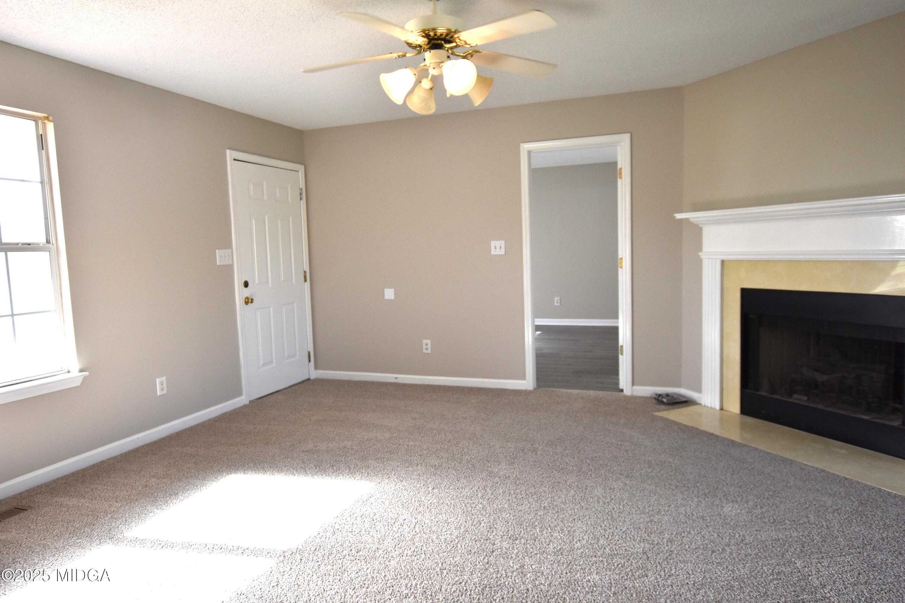 6550 Skipper Road Macon, GA 31216 - Photo 26 of 35 a view of an empty room with a fireplace and a window