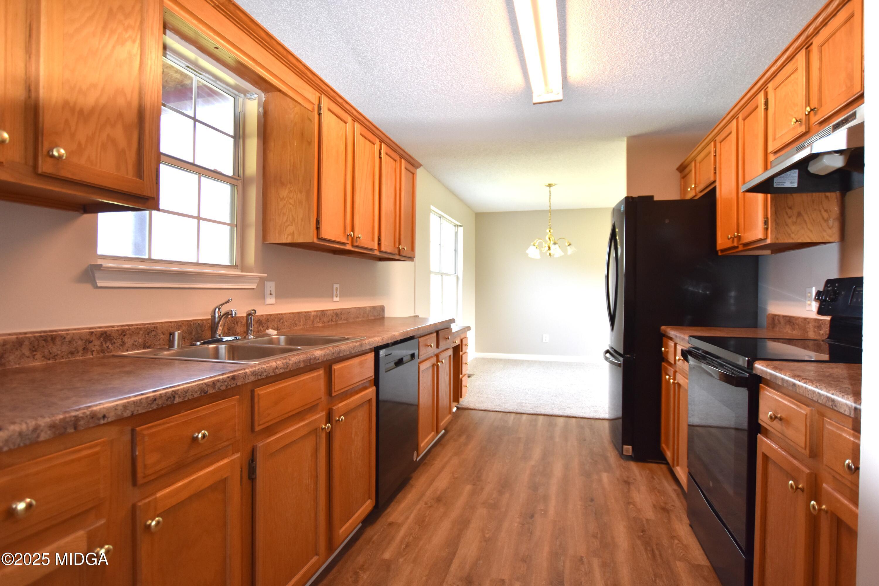 6550 Skipper Road Macon, GA 31216 - Photo 31 of 35 a kitchen with stainless steel appliances granite countertop a sink a stove and a refrigerator