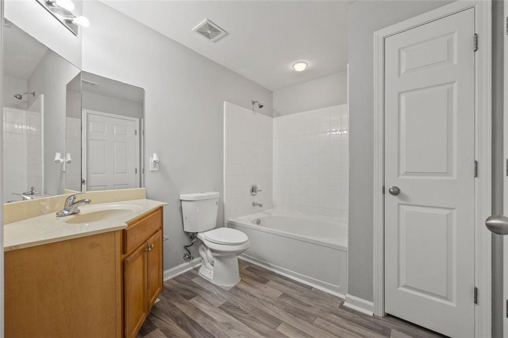 1752 Pryor Road Southwest, Unit 111 Atlanta, GA 30315 - Photo 13 of 21 a bathroom with a sink toilet a mirror and shower