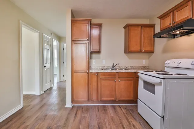 a kitchen with granite countertop a sink and a stove top oven