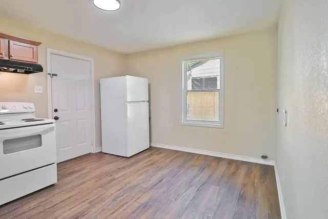 a view of a kitchen with wooden floor and electronic appliances