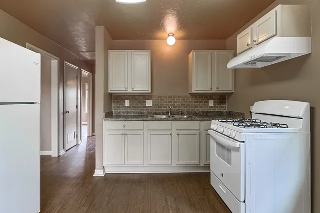 a kitchen with stainless steel appliances granite countertop a stove a refrigerator and a microwave