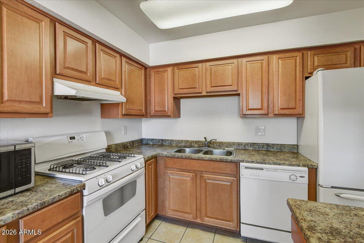 303 North Miller Road, Unit 2002 Scottsdale, AZ 85257 - Photo 5 of 12 a kitchen with stainless steel appliances granite countertop a stove a sink dishwasher and a refrigerator