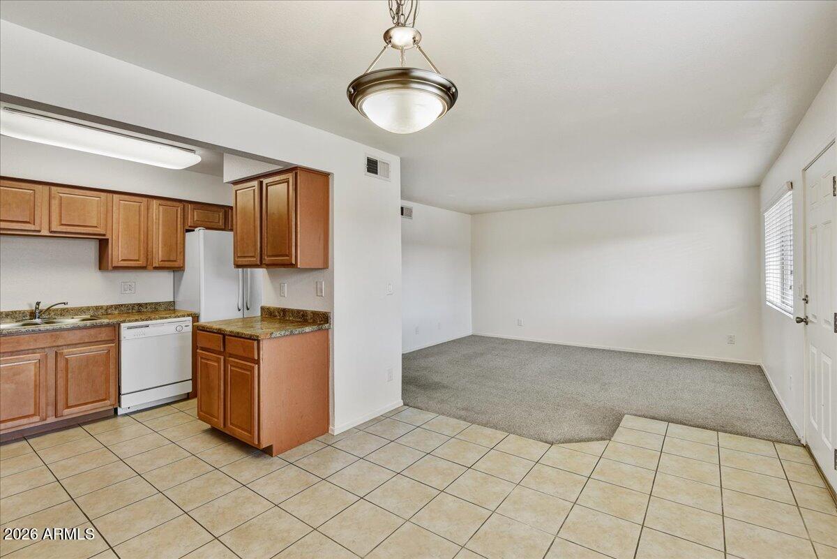 303 North Miller Road, Unit 2002 Scottsdale, AZ 85257 - Photo 6 of 12 a kitchen with stainless steel appliances granite countertop a sink dishwasher stove top oven and cabinets