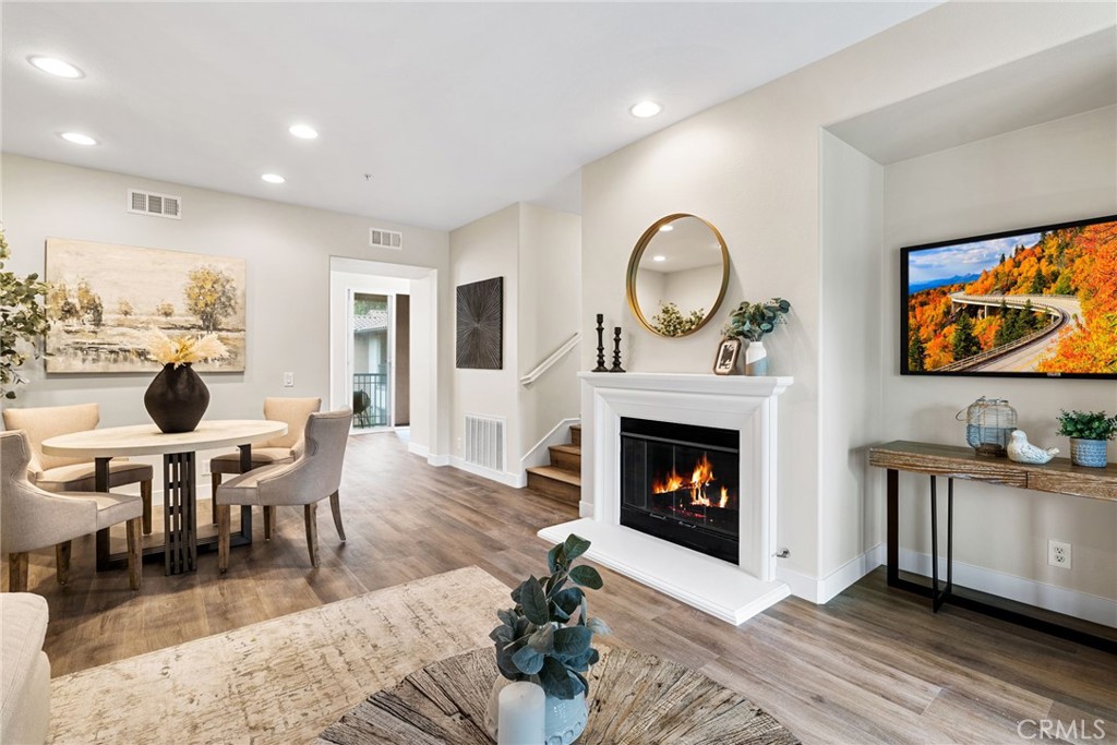 61 Stepping Stone Irvine, CA 92603 - Photo 2 of 24 a living room with furniture a fireplace and a flat screen tv