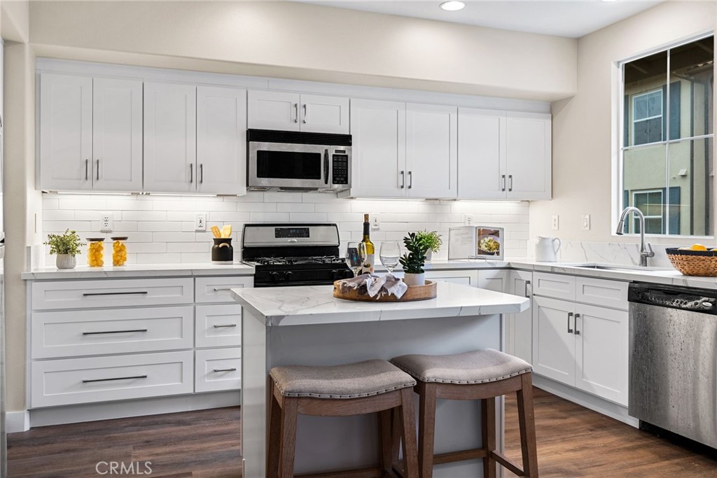 61 Stepping Stone Irvine, CA 92603 - Photo 3 of 24 a kitchen with white cabinets and appliances