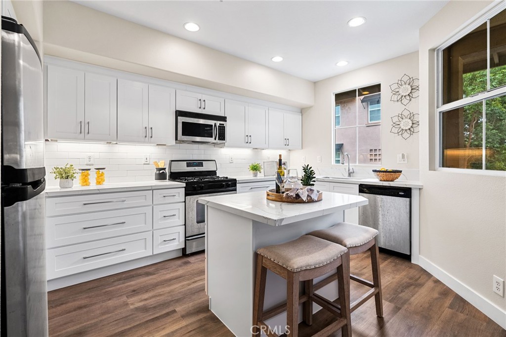 61 Stepping Stone Irvine, CA 92603 - Photo 7 of 24 a kitchen with a sink stove and white cabinets