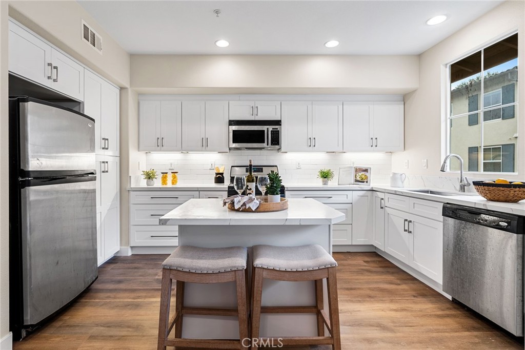61 Stepping Stone Irvine, CA 92603 - Photo 8 of 24 a kitchen with a refrigerator and a stove top oven