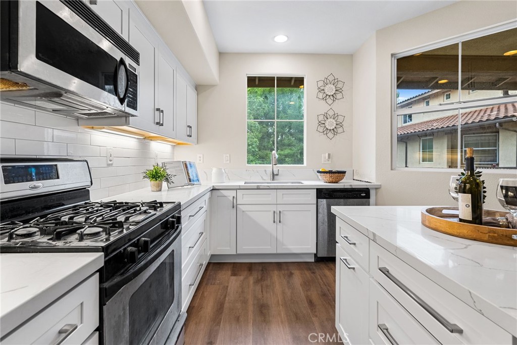 61 Stepping Stone Irvine, CA 92603 - Photo 10 of 24 a kitchen with stainless steel appliances a stove a sink and a microwave