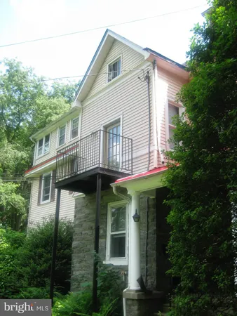 a view of a white house next to a yard