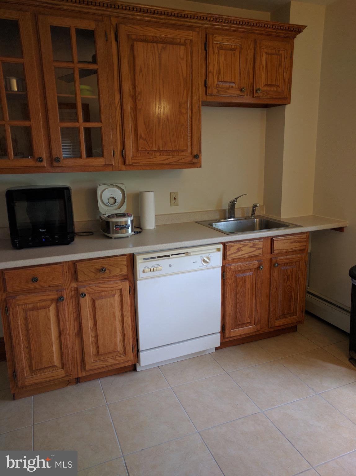 101 South Princeton Avenue, Unit 2B Swarthmore, PA 19081 - Photo 6 of 11 a kitchen with stainless steel appliances granite countertop a stove a microwave oven and a sink with cabinets
