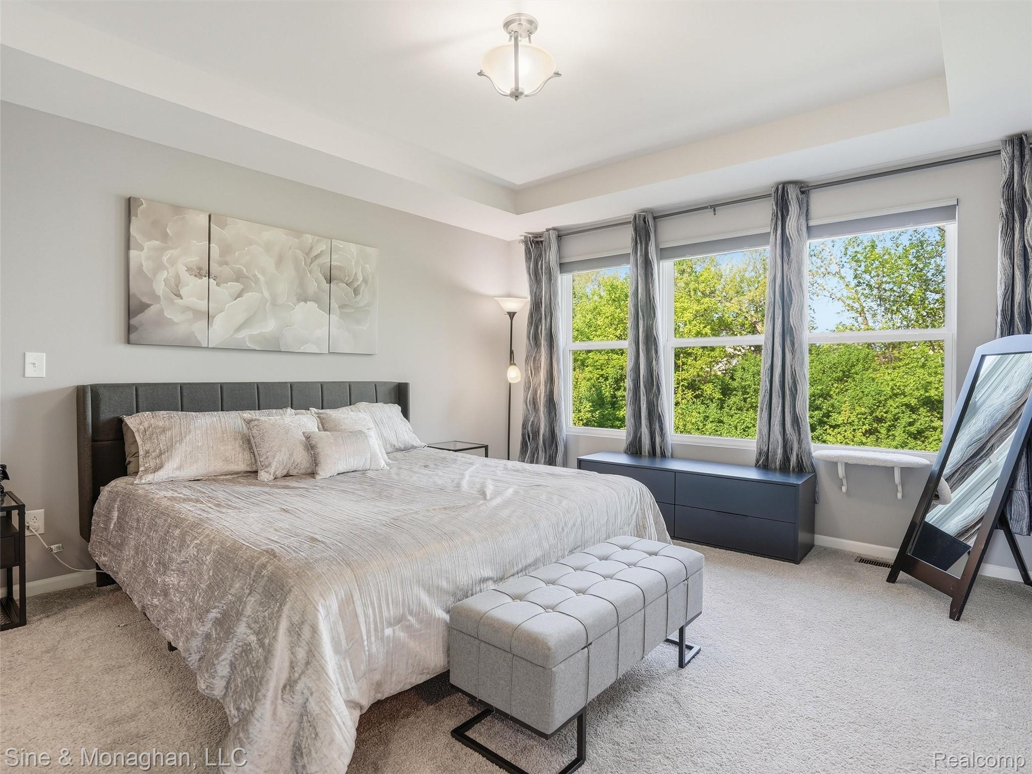24827 Ivy Road Novi, MI 48375 - Photo 15 of 38 Spacious room featuring three large windows, tray ceiling, and neutral-toned wall-to-wall carpeting