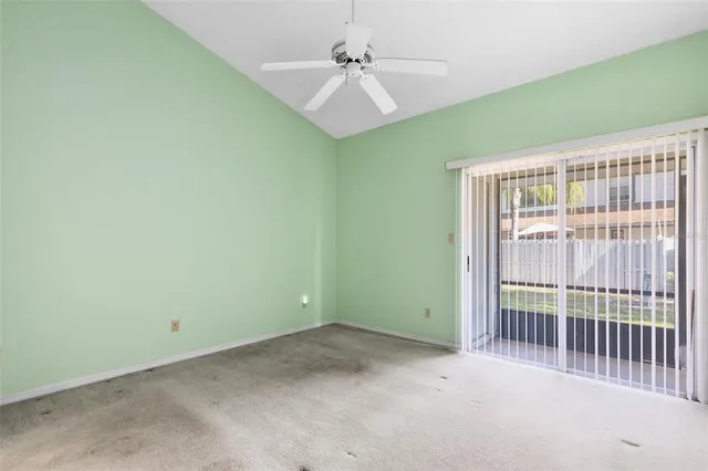 a view of a room with a ceiling fan and a window