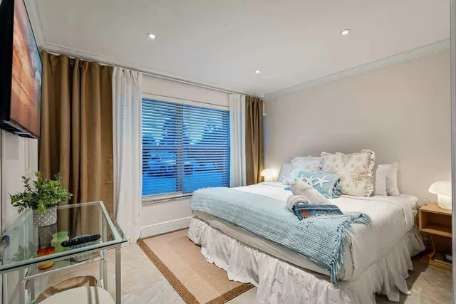 a bedroom with a large bed and a potted plant