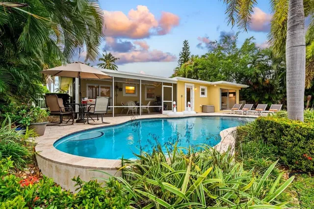 a view of a white house with a swimming pool and sitting area