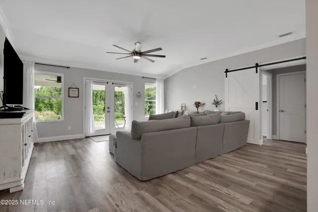 a kitchen with stainless steel appliances a refrigerator a sink dishwasher a stove and white cabinets with wooden floor