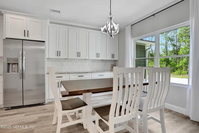 an open kitchen with wooden floor and stainless steel appliances