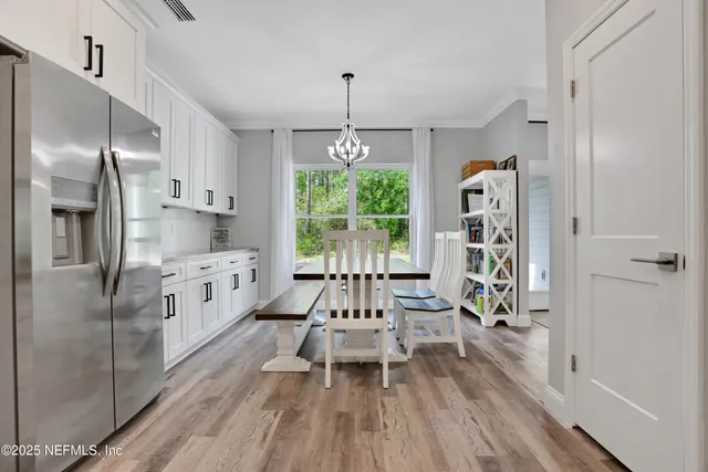 a kitchen with granite countertop wooden floors appliances and cabinets