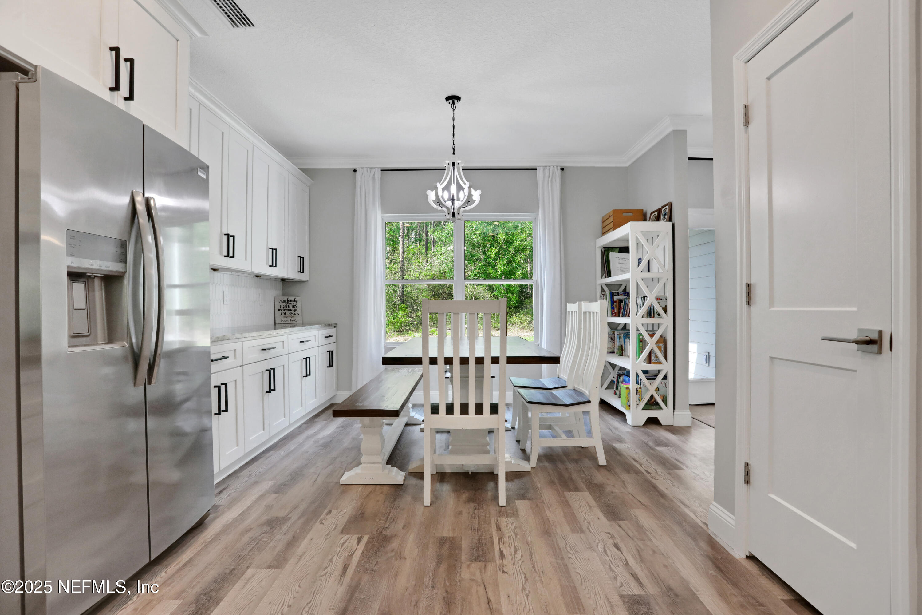 4467 Monroe Smith Road Jacksonville, FL 32210 - Photo 21 of 61 a kitchen with stainless steel appliances a refrigerator a sink dishwasher a stove and white cabinets with wooden floor