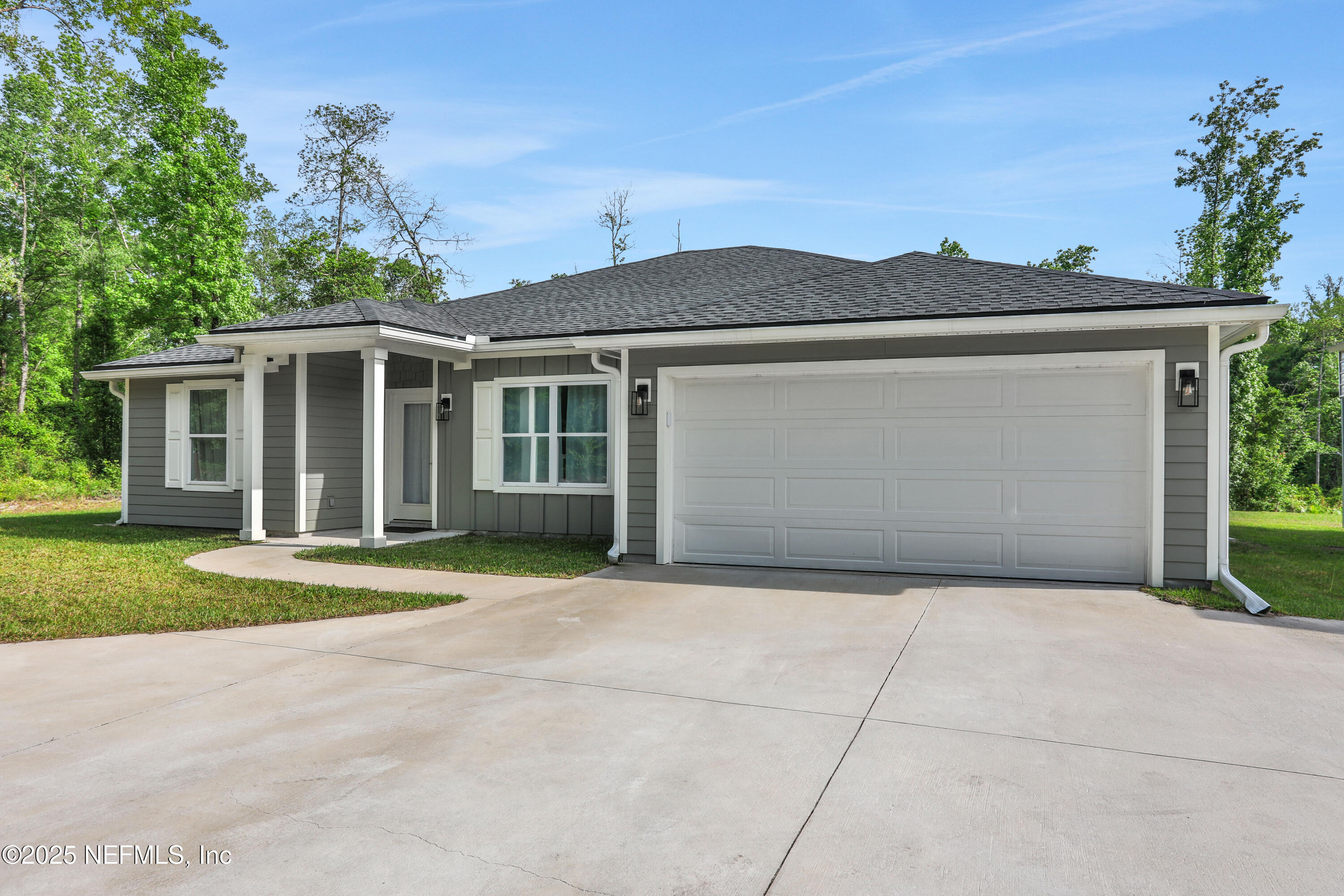 4467 Monroe Smith Road Jacksonville, FL 32210 - Photo 3 of 61 a front view of a house with a yard and garage