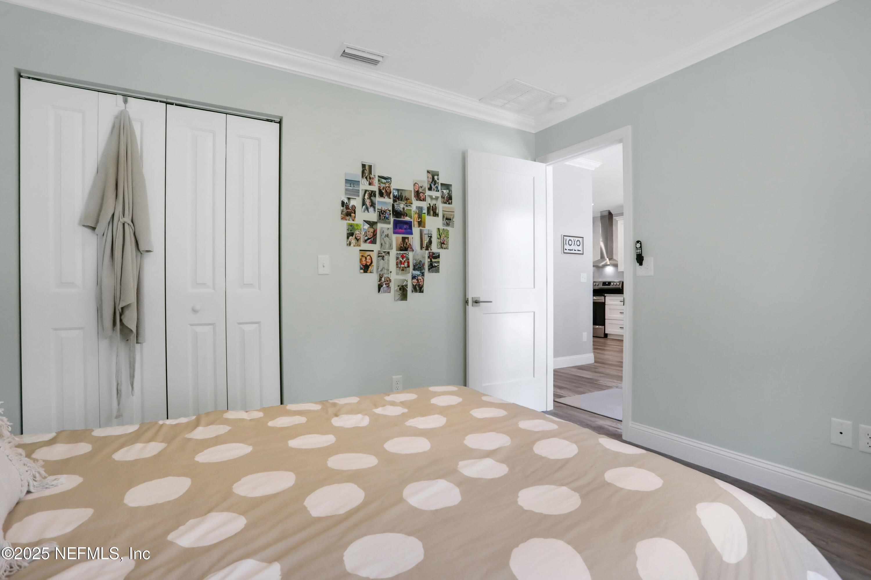 4467 Monroe Smith Road Jacksonville, FL 32210 - Photo 32 of 61 a bedroom with a large bed and a chandelier