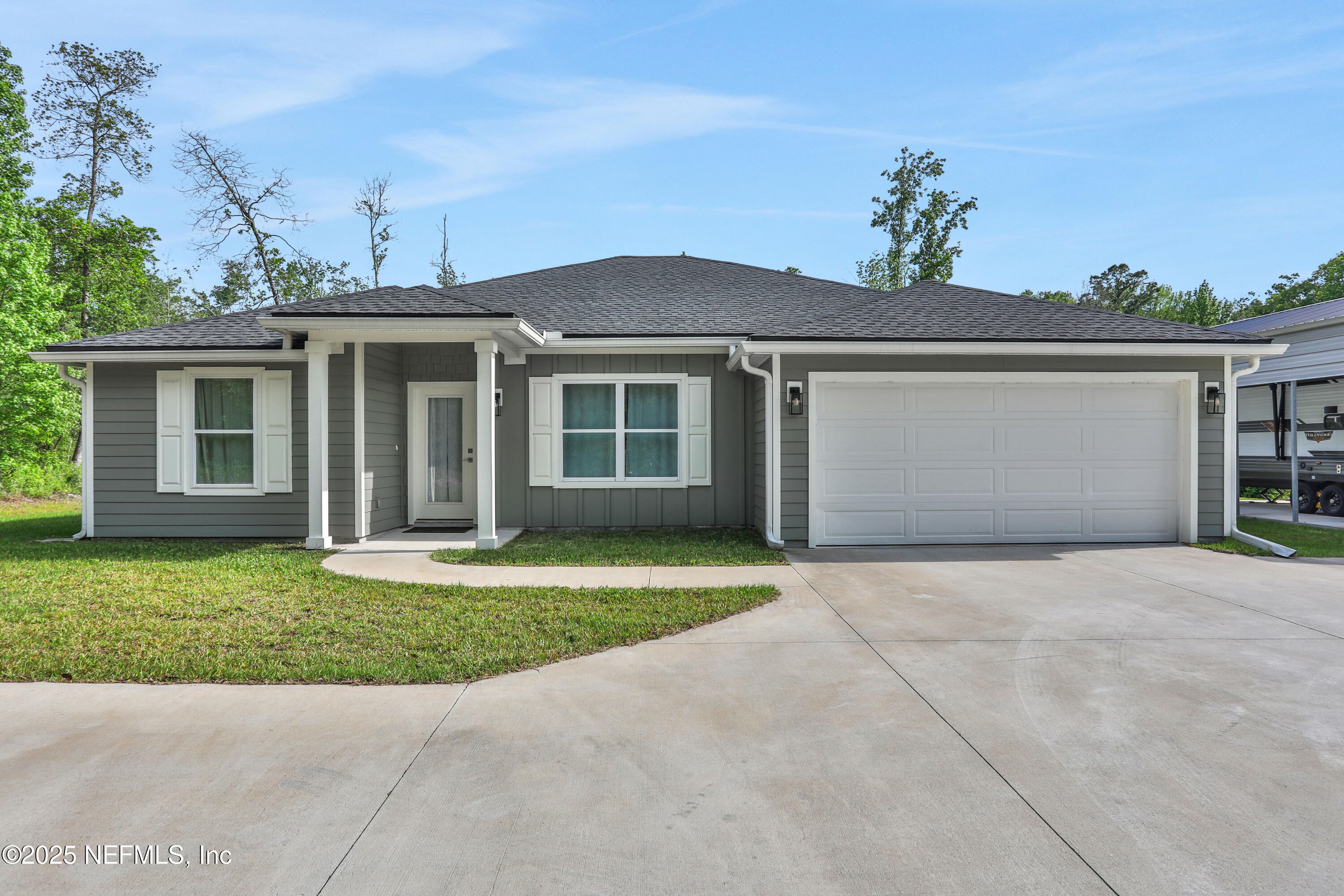 4467 Monroe Smith Road Jacksonville, FL 32210 - Photo 4 of 61 a front view of a house with a yard and a garage