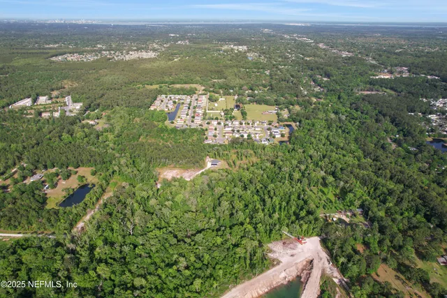 an aerial view of residential houses with outdoor space and trees