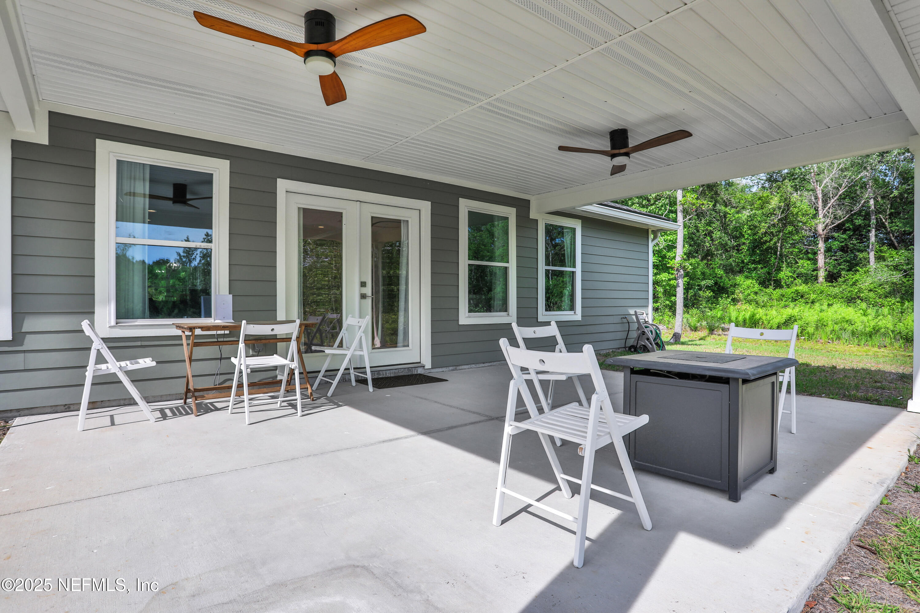 4467 Monroe Smith Road Jacksonville, FL 32210 - Photo 59 of 61 a patio with table and chairs and potted plants