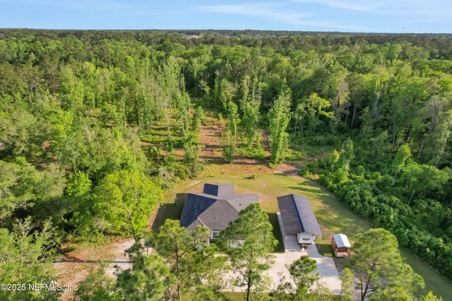 an aerial view of a house with yard and green space