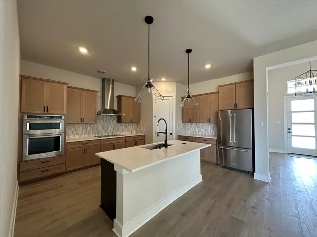 a kitchen with refrigerator cabinets and wooden floor