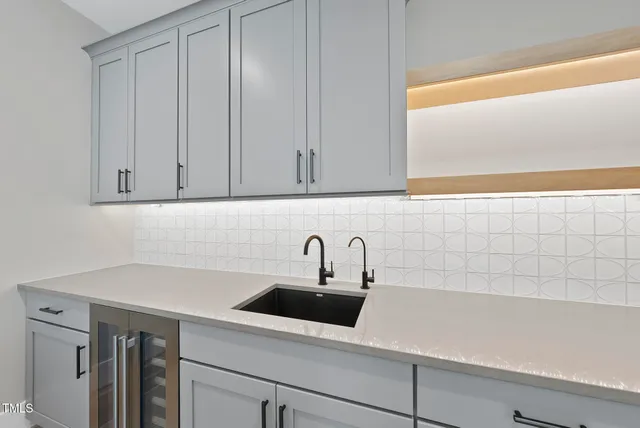 a kitchen with granite countertop a sink a stove top oven and wooden floor