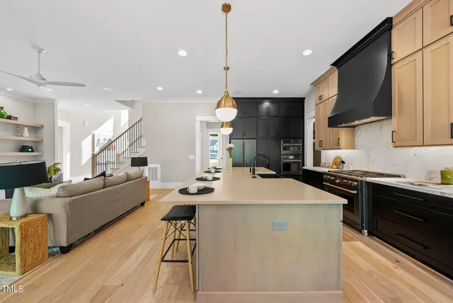 a kitchen with stainless steel appliances kitchen island granite countertop a table chairs stove and microwave