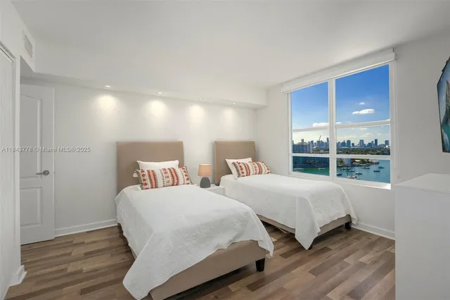 a bedroom with two beds and a large window