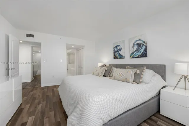 a bedroom with a bed and a painting on the wall