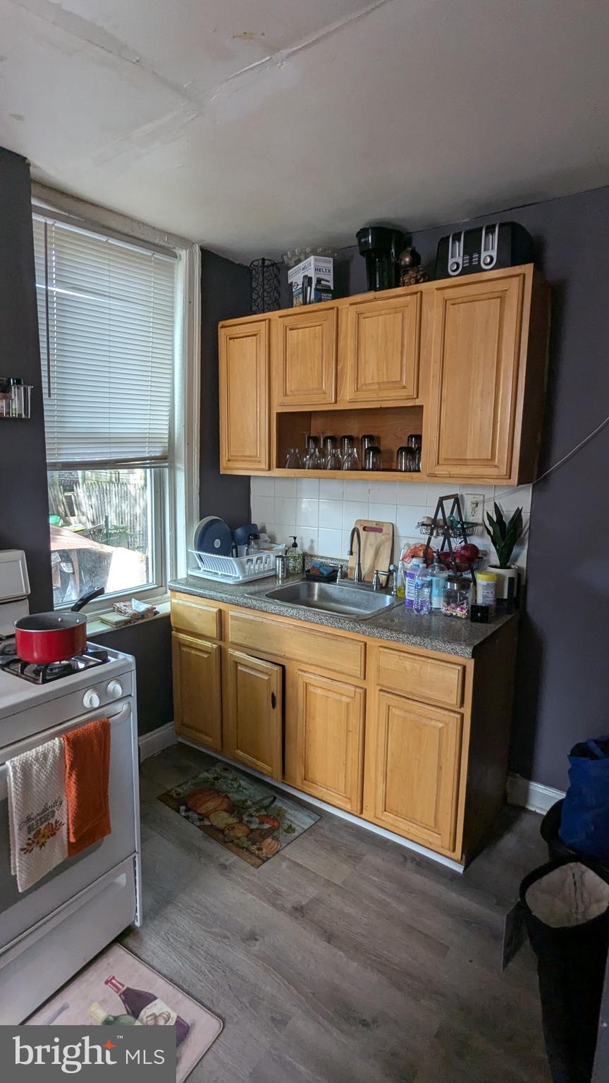 1850 South 54th Street Philadelphia, PA 19143 - Photo 5 of 13 a kitchen with granite countertop a stove a sink and a microwave