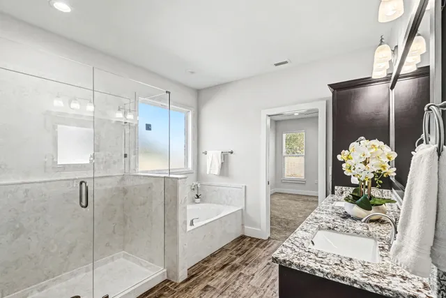 a spacious bathroom with a granite countertop shower a sink and a mirror