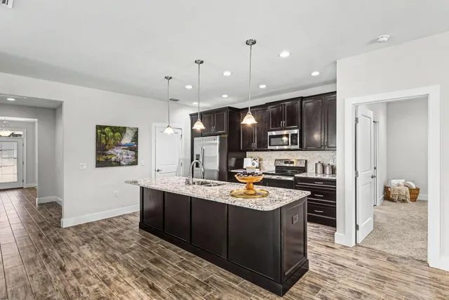 a kitchen with stainless steel appliances granite countertop a sink stove and refrigerator