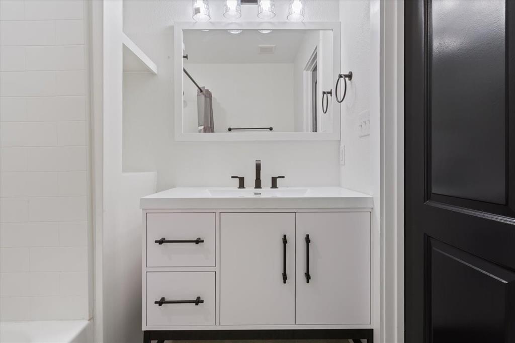 108 Private Road Whitney, TX 76692 - Photo 12 of 36 First primary bathroom #1. White vanity with black hardware, integrated sink, and wall-mounted faucet