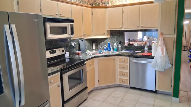 a kitchen with stainless steel appliances granite countertop a refrigerator stove and sink