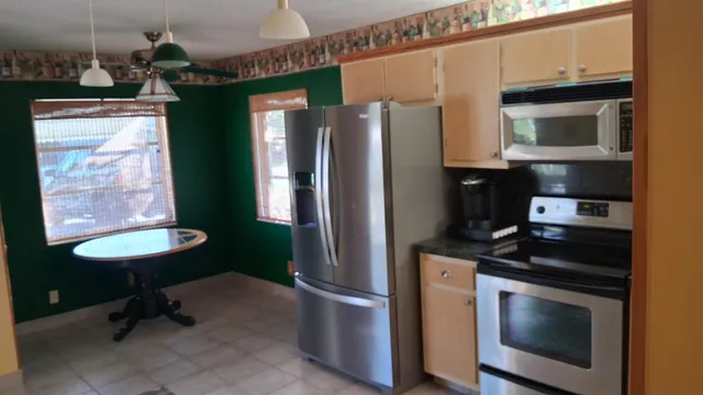 a kitchen with stainless steel appliances a stove a refrigerator and a microwave