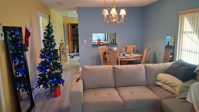 a living room with furniture a chandelier and a flat screen tv
