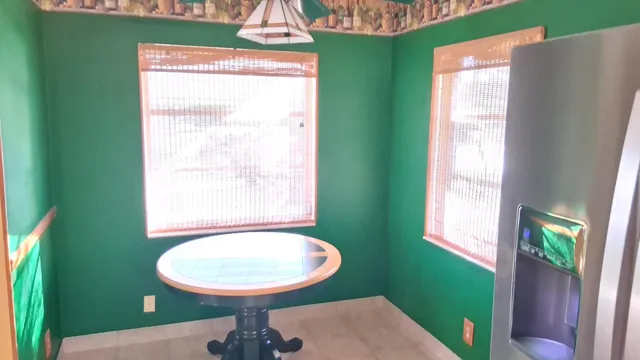 a bed sitting in a bedroom next to a window with wooden floor