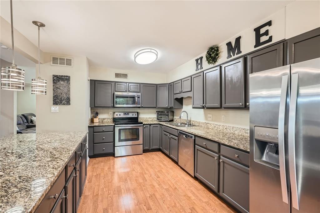 81 La Rue Place Northwest Atlanta, GA 30327 - Photo 8 of 24 a large kitchen with stainless steel appliances granite countertop a refrigerator a stove and a sink