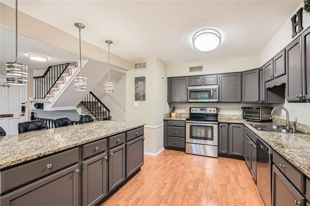 81 La Rue Place Northwest Atlanta, GA 30327 - Photo 9 of 24 a kitchen with granite countertop stainless steel appliances and wooden cabinets