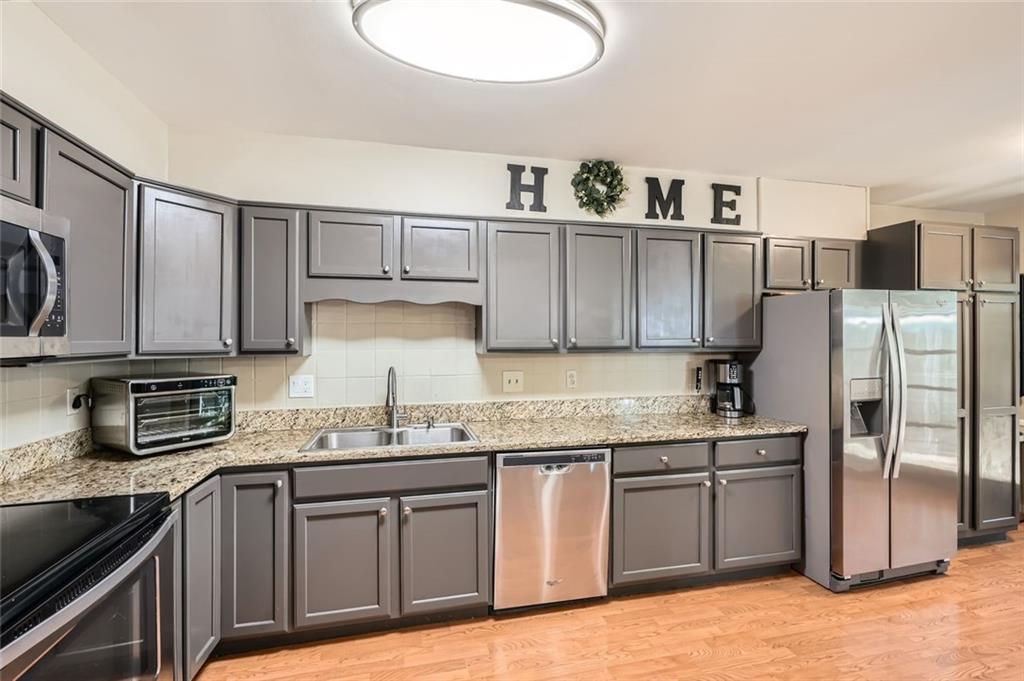 81 La Rue Place Northwest Atlanta, GA 30327 - Photo 10 of 24 a kitchen with stainless steel appliances granite countertop a sink stove and refrigerator