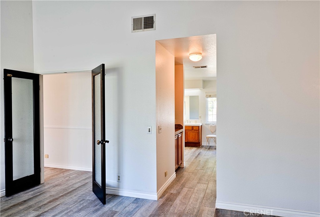 33342 Trail Ranch Road Agua Dulce, CA 91390 - Photo 25 of 40 a view of a hallway with wooden floor and bathroom